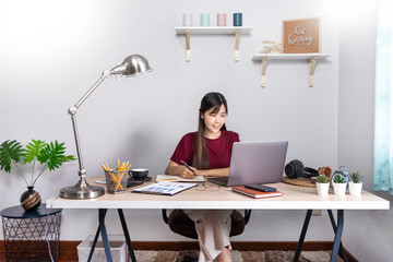 Pensive asian woman is relaxing on  desktop working remotely from home with laptop for communicates on internet with customer, E learning learn teach in online chat, quarantine Coronavirus concept.