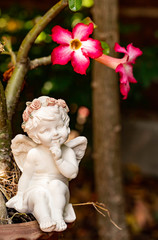 Little porcelain girl figurine sit under the tree