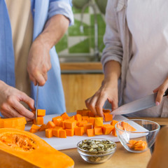 Young vegan couple cooking vegetarian soup in the kitchen
