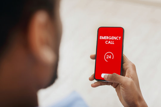 Black man holding smart phone with emergency number