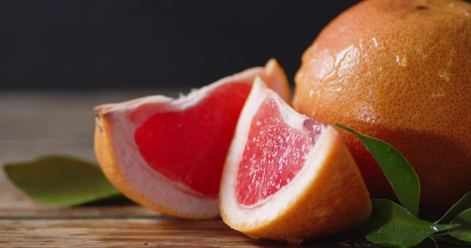 On juicy grapefruit with leaves falling drops of water.