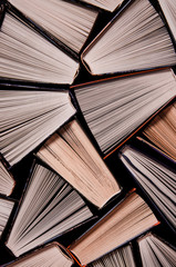 Fototapeta premium Many open old multicolored books stand on the bookshelf