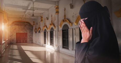 Fototapeta na wymiar Traveller Muslim woman praying for god in front of public Mosque in Bangkok, Thailand, woman with black niqab and hijab