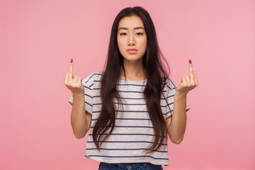 Portrait of annoyed rude vulgar girl with long brunette hair showing fuck off sign, expressing...