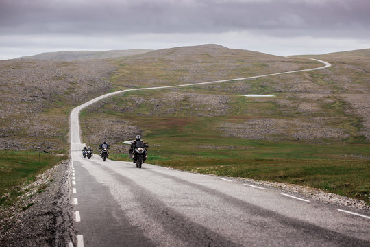 Three motorcyclists on a winding road to the North Cape (Nordkapp)