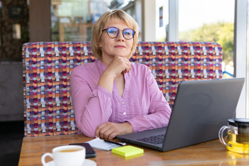 A woman is working with a laptop at a table in the room