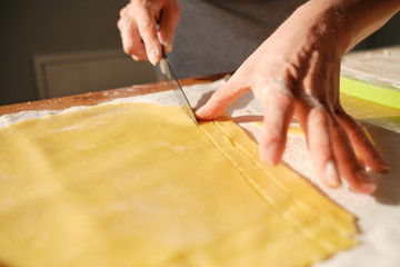 Obraz premium Close up woman hands, cutting dough in the sunlight on the table