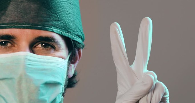 Medico fa il segno di vittoria con le mani dopo la sconfitta definitiva del coronavirus.