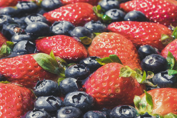 Obraz premium Strawberries and blueberries floating on the water.