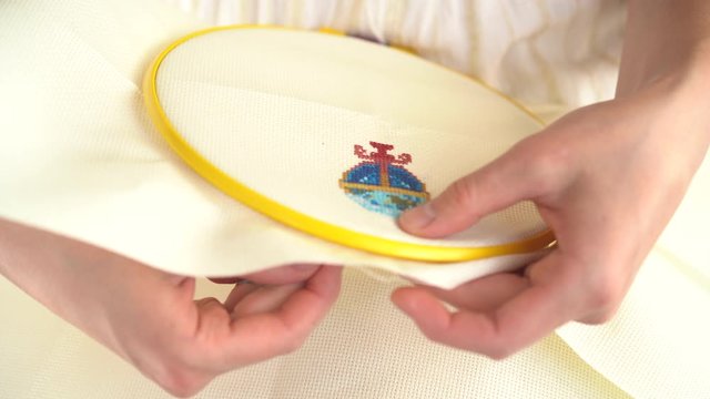 close up of cross-stitching, needlework 4k. female hands embroider a picture