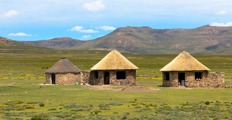 Traditional rural round huts in a Lesotho village in the countryside near Sani Pass road,  Basotho Drakensberg - obrazy, fototapety, plakaty