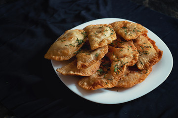 nine pork pies on a white plate on a black background
