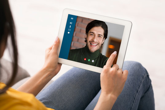 Social distancing and online communication. Young woman chatting with her boyfriend via tablet at home