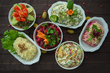 Diet salad with beets . Capital salad . Potato salad . coleslaw salad . set with different salads . Salad ham, orange pepper, mushrooms, pickles, white sauce, on a white bowl.