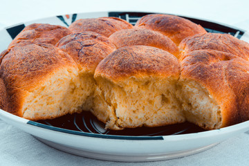 Sunday morning breakfast. Beautiful homemade baked brioche bread in a dish, with a bun on top, on a spotless white tablecloth. International recipe, italian style. Good vibes from food.