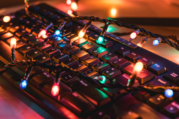 Computer keyboard wrapped over colored lights
