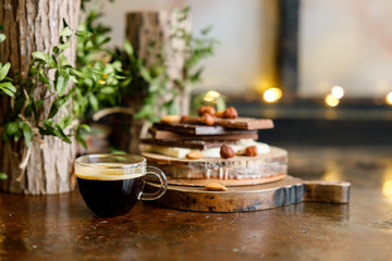 cup of coffee with tiled chocolates and different varieties and nuts