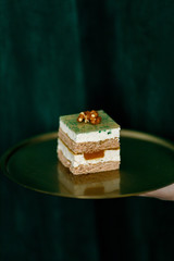 green mousse cake puff pastry with walnut on a green background