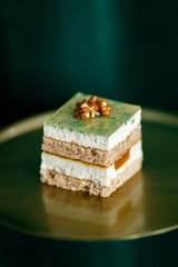 green mousse cake puff pastry with walnut on a green background
