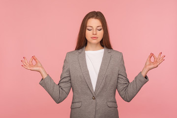Mind control, yoga practice. Portrait of young woman in business suit meditating with namaste...