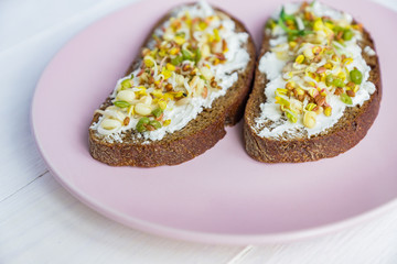 Top view of rye bread sandwiches with cream cheese and sprouted mung beans, walnut, sunflower and flax. raw food diet.