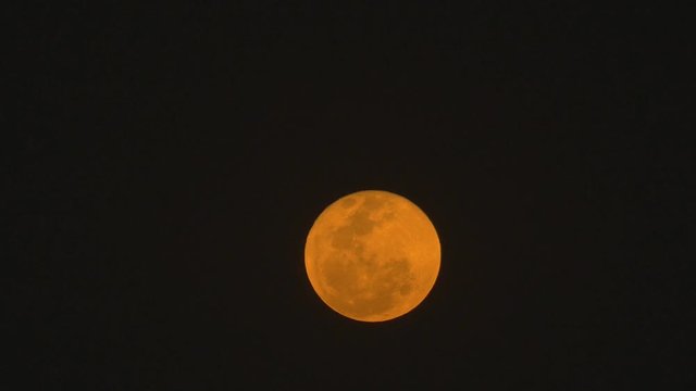 A Super Moon rises in the sky during the full moon time in India filmed from the western part of India in Pune , its a time-lapse of the rise of the moon which looks orange