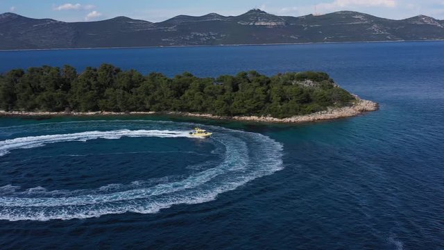 Speed Coast Guard Boat navigating near beautiful Island in Adriatic Sea - Aerial Drone View