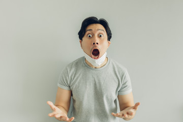 Shocked and surprised face of Asian man wearing hygienic mask in grey t-shirt.