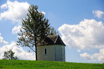 Obraz premium Chapel on green field with blue sky