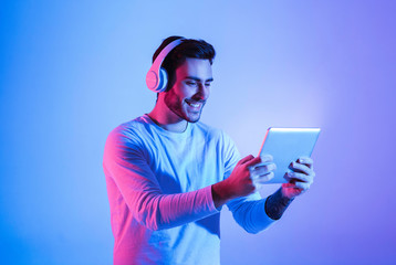 Modern games with devices. Man playing at tablet