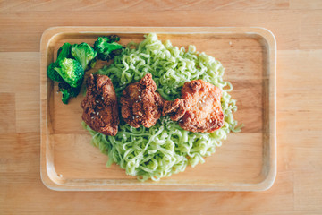 Green noodle with chicken karaake served on the table.
