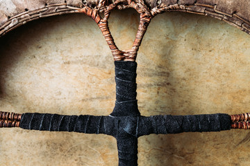 Details of shamanic tambourine. Leather-braided handle, handmade, close-up view.