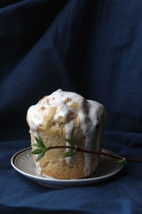 Russian traditional easter kulich cake with sprig of Jasmine on white gold vintage plate deep blue background