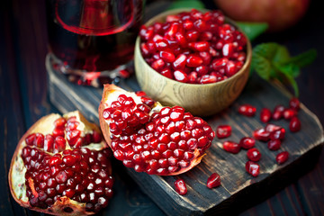 Ripe pomegranate fruit on a old black wooden vintage background. Selective focus.