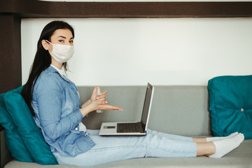 Health care and hygiene. Woman in face mask spreading sanitizer on hands before touching laptop. Infection diseases prevention. Obsessive-compulsive disorder