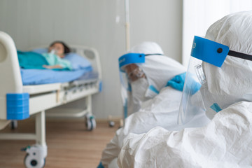 doctor in personal protective equipment or ppe feeling sad after patient with covid-19 or coronavirus infection has died in the isolation unit during pandemic. medical concept - obrazy, fototapety, plakaty