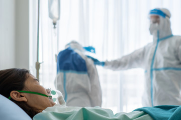 doctor in personal protective equipment or ppe feeling sad after patient with covid-19 or...