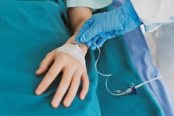 close up picture of doctor wearing gloves giving intravenous fluid to the critical patient with covid-19 or coronavirus infection. medical concept (fouus at doctor's hand)