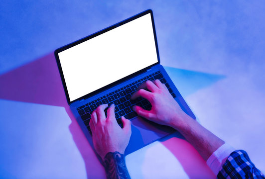 Man typing on laptop with blank screen