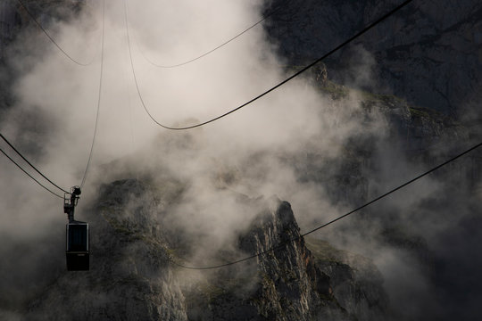 Cable car among the fog in Fuente De