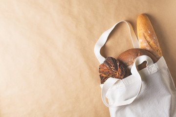 Zero waste concept with fresh bread in cloth bag eco friendly on brown, beige background