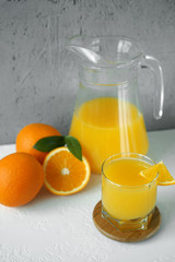 Fototapeta na wymiar orange juice and oranges on white table