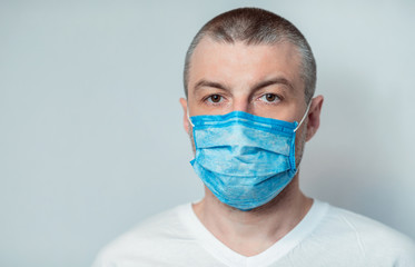 Sick Man Wearing Mask Looking At Camera On Gray Background