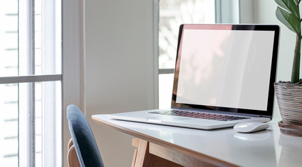 Obraz na płótnie Canvas Blank screen laptop on wooden table in modern house.
