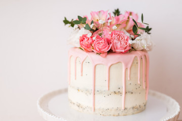 beautiful homemade cake decorated with flowers . Pink icing, sponge cakes