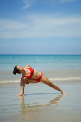 Asian Chinese Woman in various yoga poses at the beach