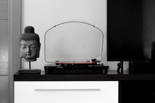 Stylish black and white house with a Buddha head and a red vinyl in turntable.