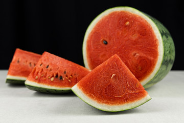 Close-up watermelon on concrete table and black color background.