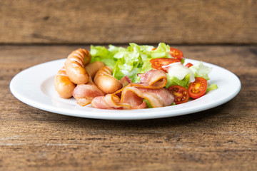 Close-up Bacon, Sausage, Salad on wooden table background.