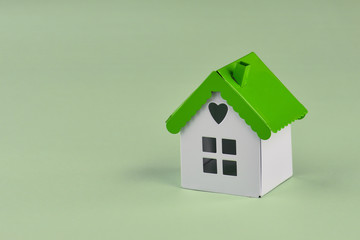 Mini model house on green background. Property investment and house mortgage financial concept..